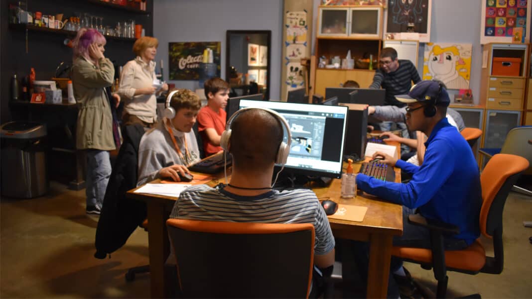 DIV2 Islands of Brilliance students work on 3D modeling as volunteers walk around to answer questions.